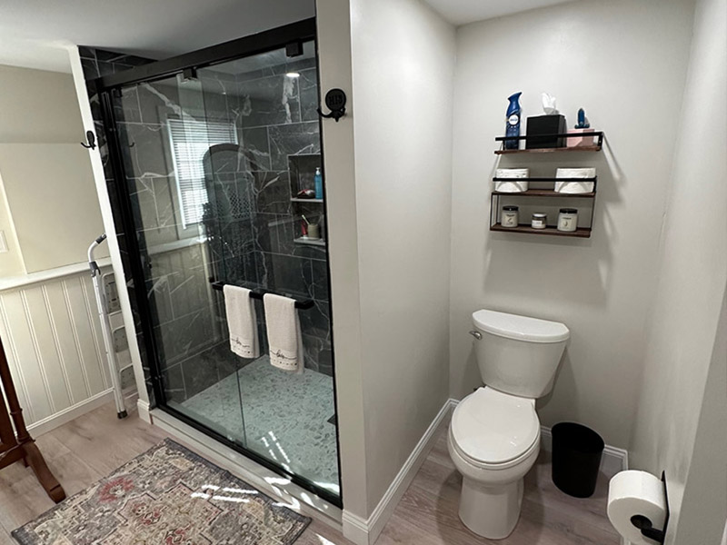 Bathroom renovation showing new flooring, glass show and stone finishes